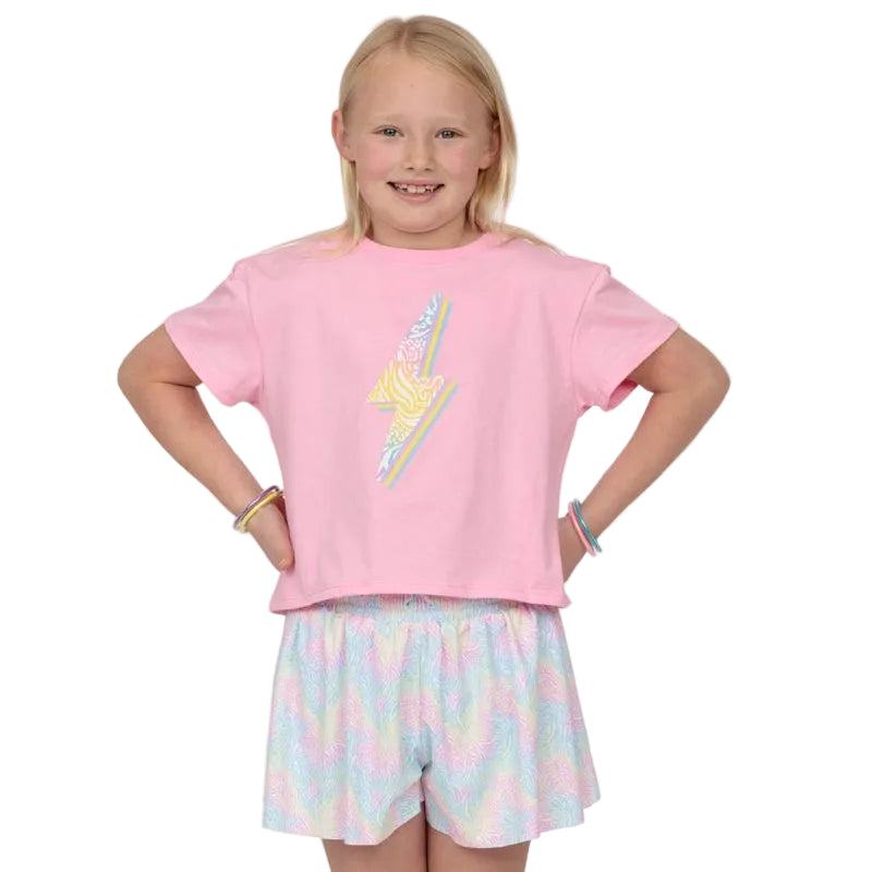 Young girl wearing a pink t-shirt with a colorful design and pastel striped shorts on a white background.