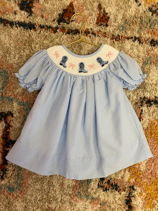 A blue smocked dress with cowboy boots and pink bows